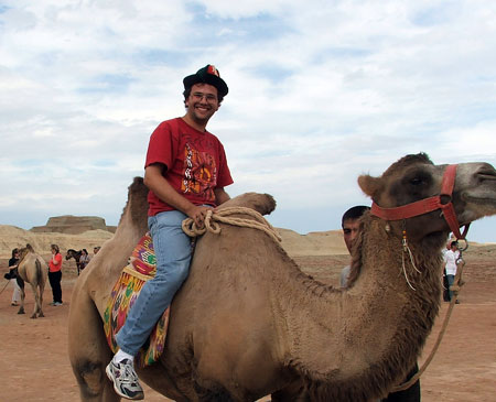 George off on a camel ride in the Gobi Desert, China.