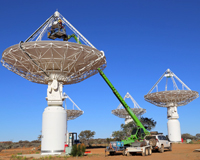 Daytime photo of dish-like radio antennas in an outback setting. Credit: CSIRO