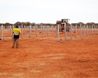 Construction vehicles installing poles in an outback setting. Credit: EMC Solar Construction.