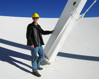 Man standing on the surface of a dish-like radio telescope antenna
