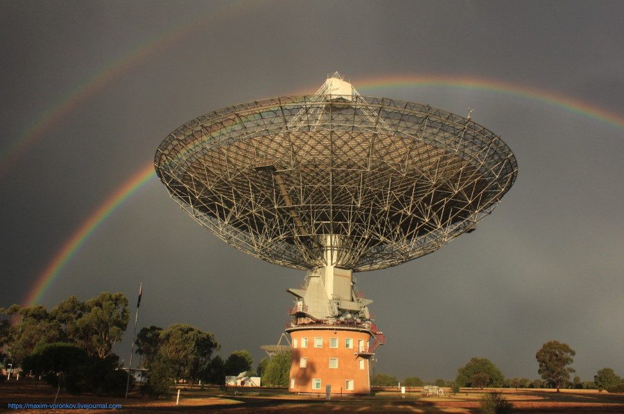 A double rainbow behind Murriyang, CSIRO's Parkes radio telescope, showing the sky is brighter inside the rainbow.